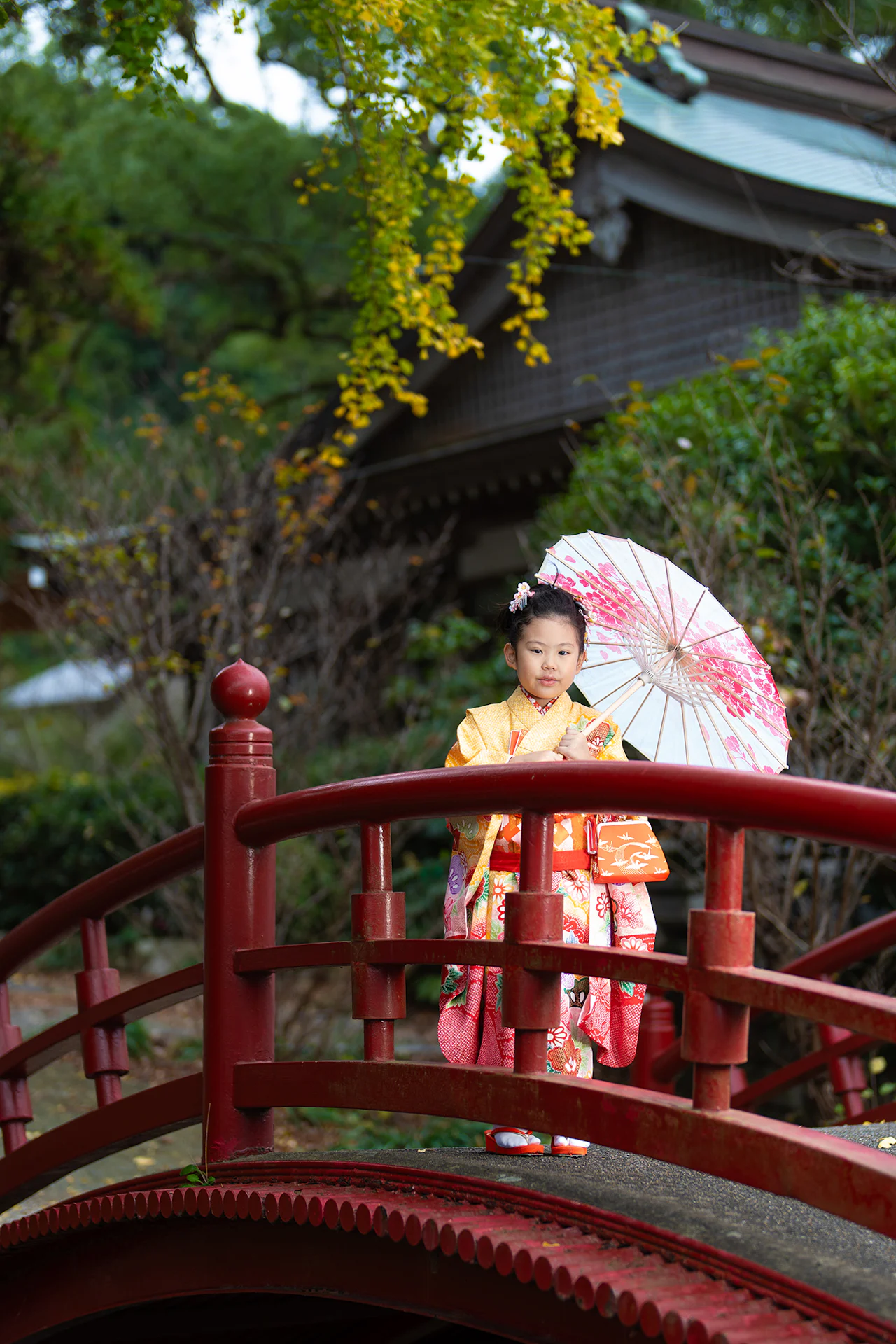 【福岡県遠賀郡岡垣町で家族写真撮影】姉妹の７歳女子と３歳女子の撮影です。岡垣の高倉神社での撮影は、今回が初めての機会でした。境内は随所にスポットライトで照らされたような美しい光が差し込み、とても雰囲気のある神社でした。また、祈祷中の撮影が許可されているのも魅力的なポイントです。2